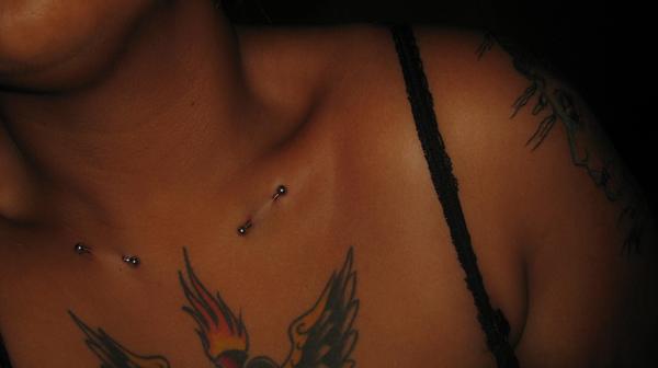 chest piercings - chest tattoo